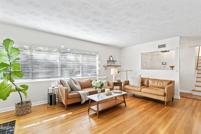 living room with wood-type flooring and a textured ceiling