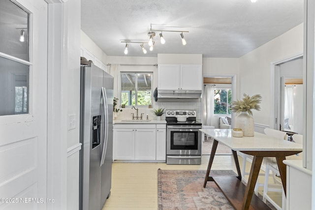 kitchen with white cabinetry, appliances with stainless steel finishes, sink, and decorative backsplash