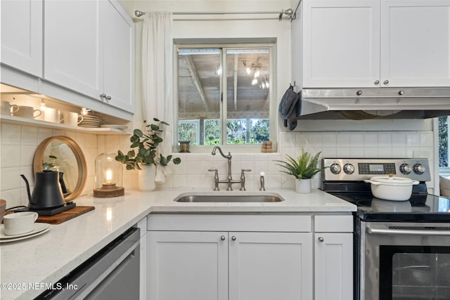 kitchen featuring stainless steel appliances, white cabinetry, sink, and backsplash