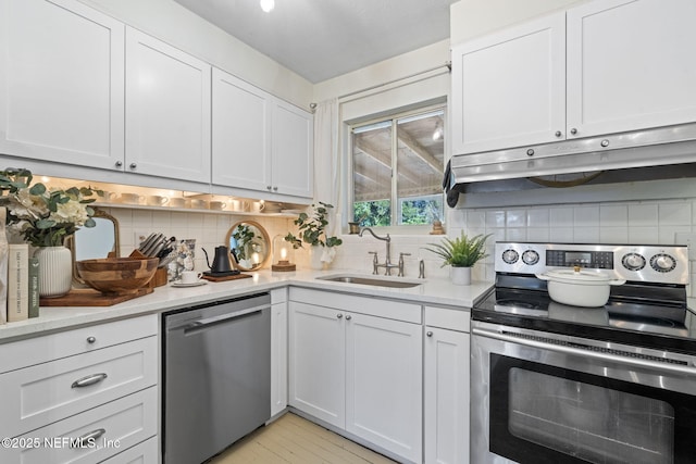 kitchen with white cabinets, appliances with stainless steel finishes, sink, and backsplash