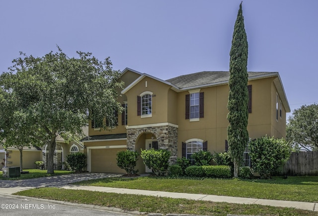 view of front facade with cooling unit, a front yard, and a garage