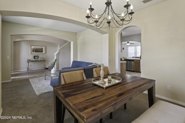 carpeted dining area with ceiling fan with notable chandelier