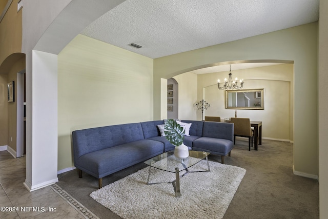 carpeted living room with a textured ceiling and an inviting chandelier