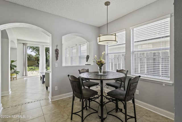 dining room featuring tile patterned floors and a textured ceiling