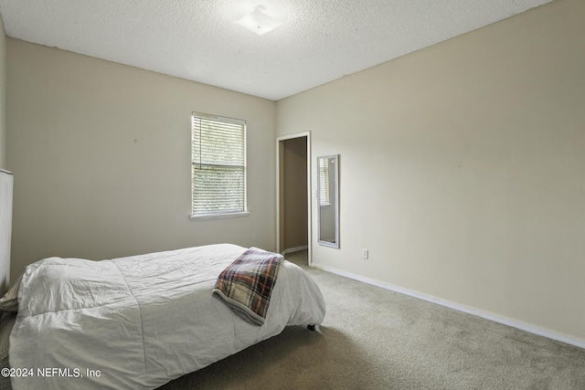 bedroom featuring carpet flooring and a textured ceiling