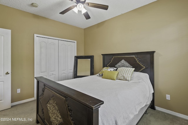 bedroom featuring ceiling fan, light colored carpet, a closet, and a textured ceiling