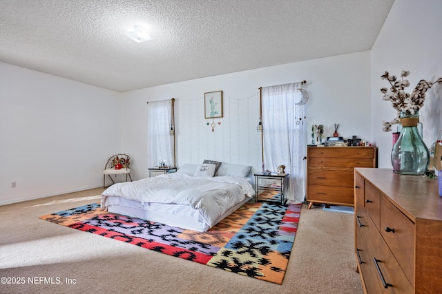 bedroom featuring light colored carpet and a textured ceiling