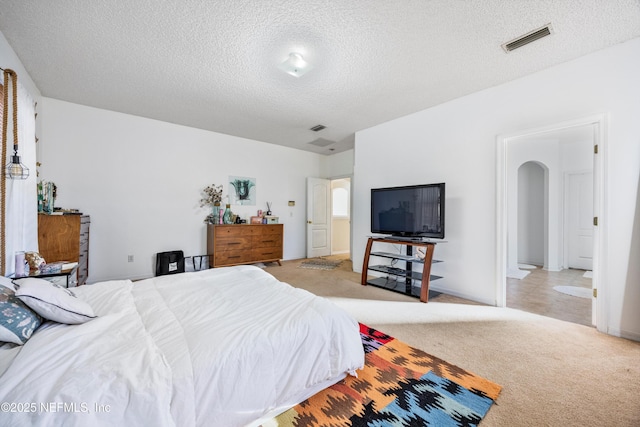 bedroom with light carpet and a textured ceiling