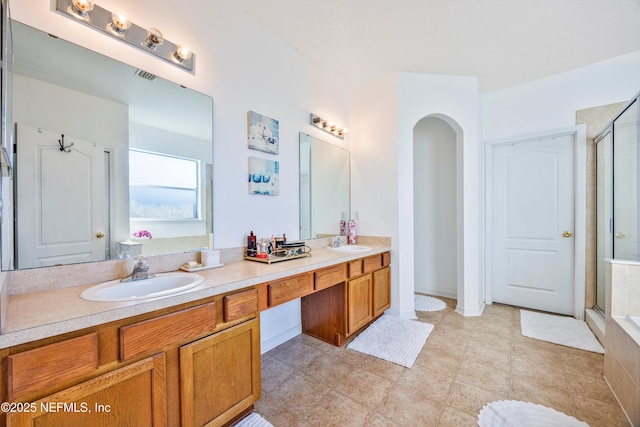 bathroom with walk in shower and vanity