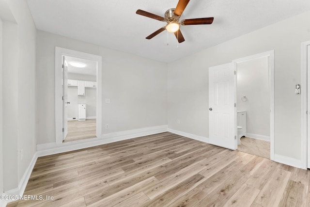 unfurnished bedroom with connected bathroom, ceiling fan, a spacious closet, and light hardwood / wood-style flooring