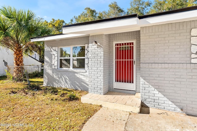 entrance to property featuring a lawn