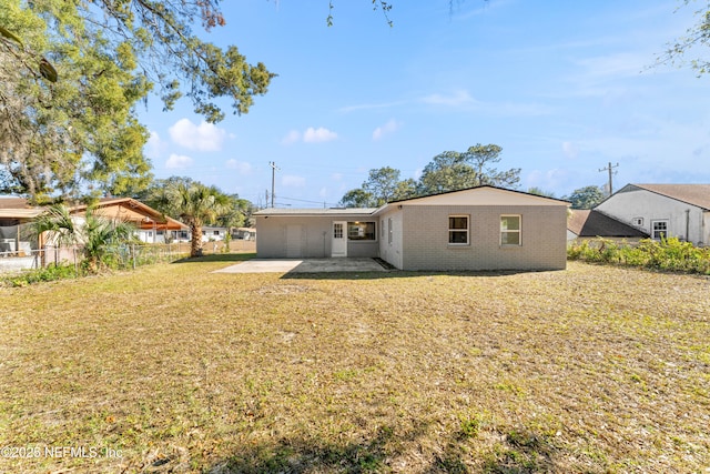 rear view of property featuring a patio area and a lawn