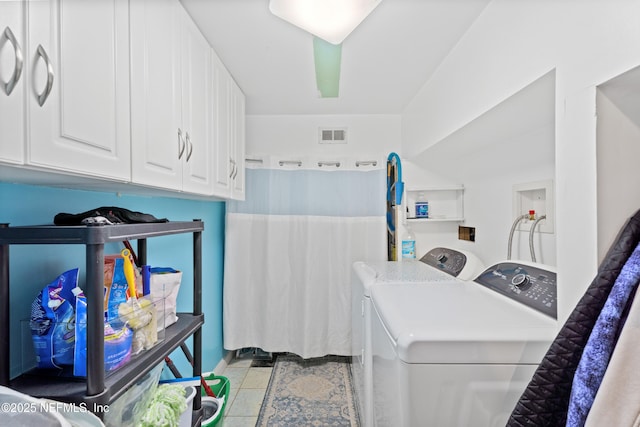 laundry area with cabinets, washer and dryer, and light tile patterned floors