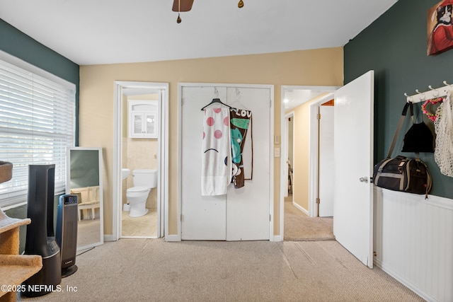 bedroom featuring ensuite bathroom and light carpet