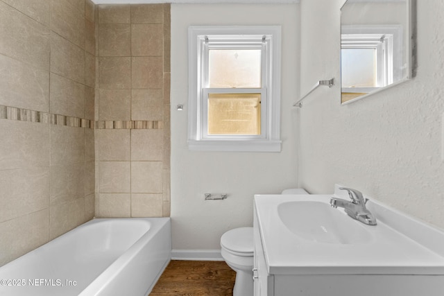 bathroom featuring a bath, vanity, hardwood / wood-style flooring, and toilet