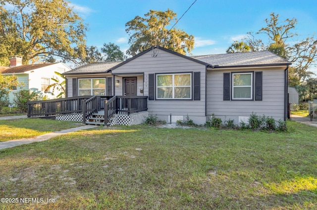 view of front of home with a front yard and a wooden deck