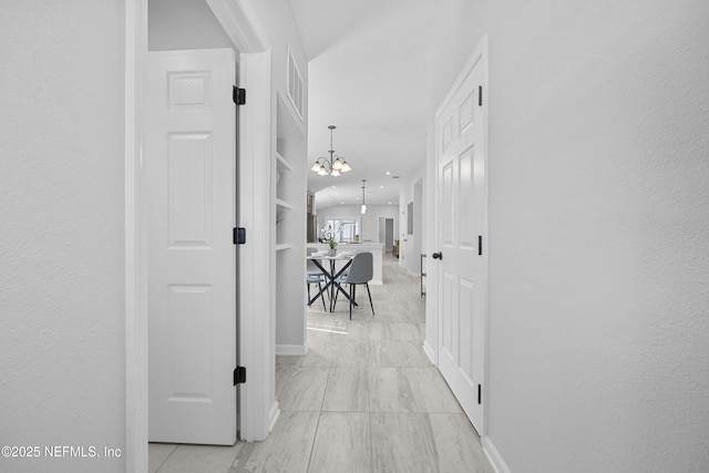 hallway featuring an inviting chandelier