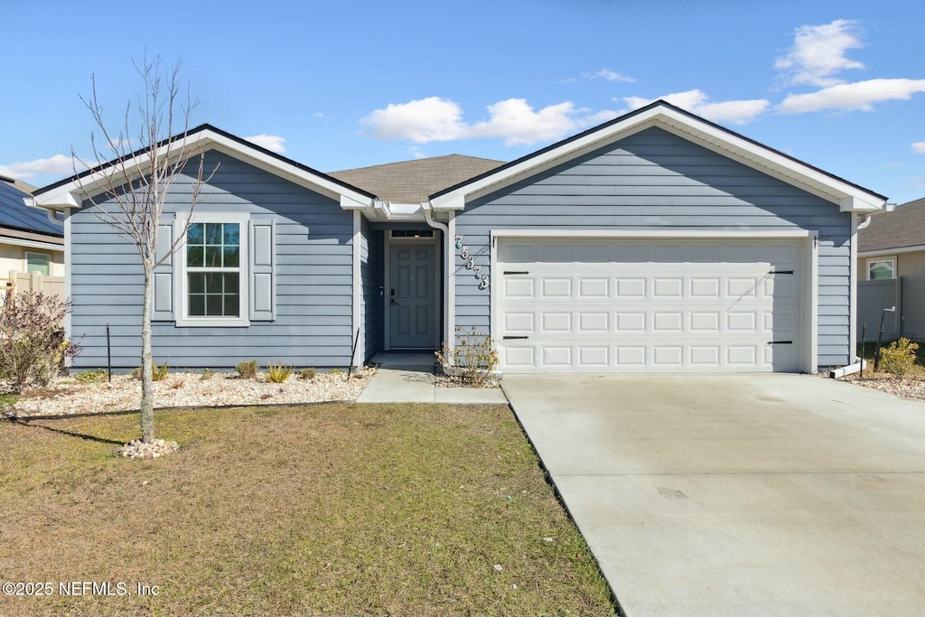 ranch-style home with a front lawn and a garage