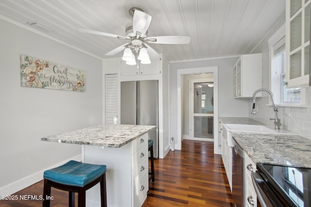 kitchen with sink, white cabinetry, a kitchen breakfast bar, ceiling fan, and dark hardwood / wood-style floors