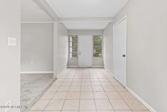 foyer featuring beam ceiling and light colored carpet