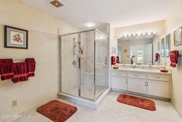 bathroom featuring tile patterned flooring, a shower with door, and vanity