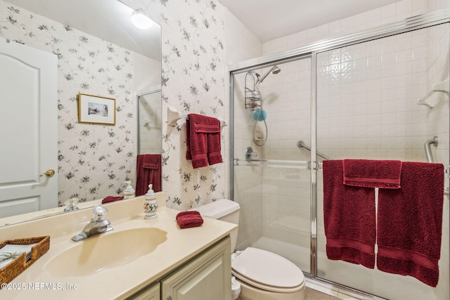 bathroom with toilet, an enclosed shower, and vanity