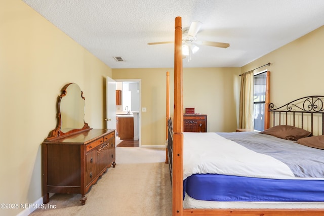 carpeted bedroom with sink, a textured ceiling, and ceiling fan