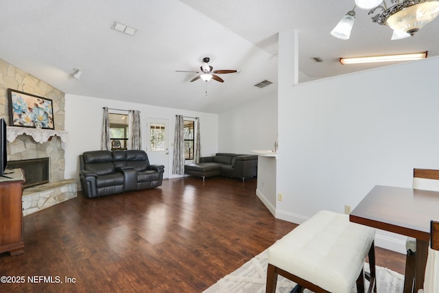 living room with ceiling fan, lofted ceiling, a fireplace, and dark hardwood / wood-style flooring