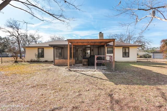 rear view of property featuring a sunroom and a yard