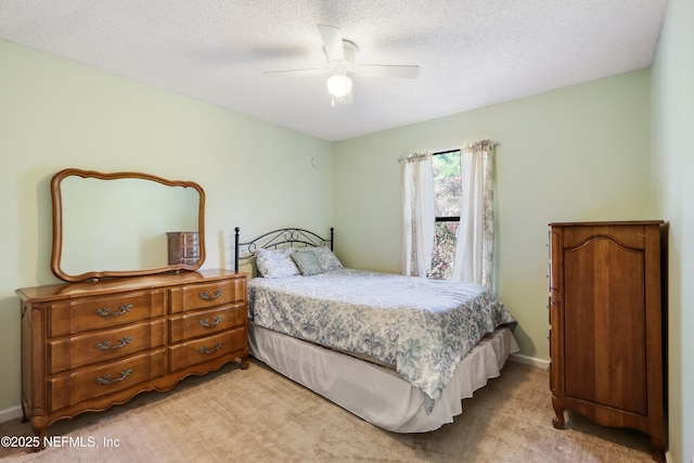 carpeted bedroom with ceiling fan and a textured ceiling