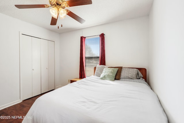 bedroom with ceiling fan, dark wood-type flooring, a closet, and a textured ceiling