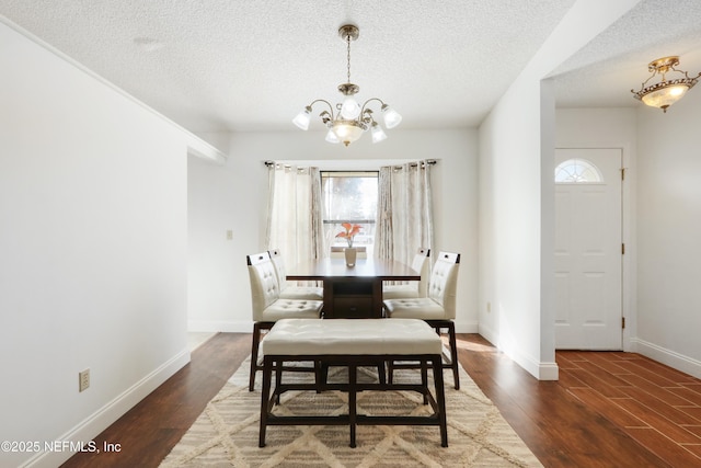 dining room featuring dark wood-type flooring, a notable chandelier, and a textured ceiling