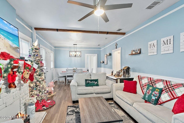 living room featuring ceiling fan with notable chandelier and hardwood / wood-style flooring