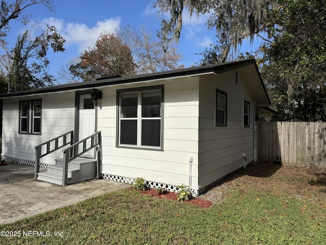 view of front of home featuring a front lawn and a patio