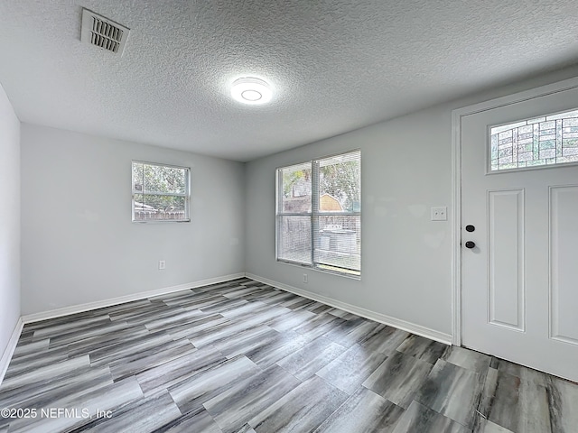 entrance foyer with wood-type flooring and a textured ceiling