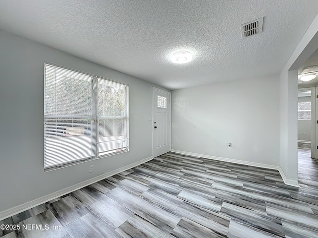 interior space with wood-type flooring and a textured ceiling