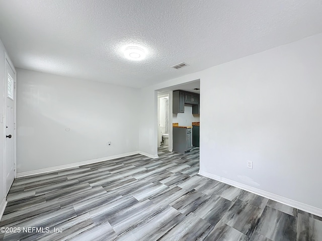 empty room featuring hardwood / wood-style flooring and a textured ceiling