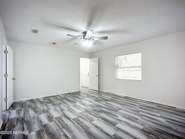 spare room with wood-type flooring, ceiling fan, and a textured ceiling