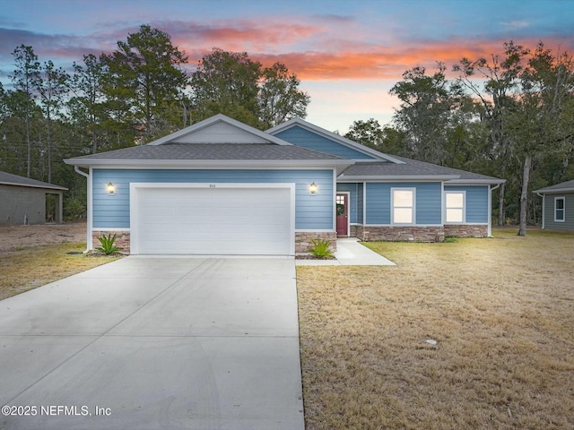 view of front of home with a garage and a yard