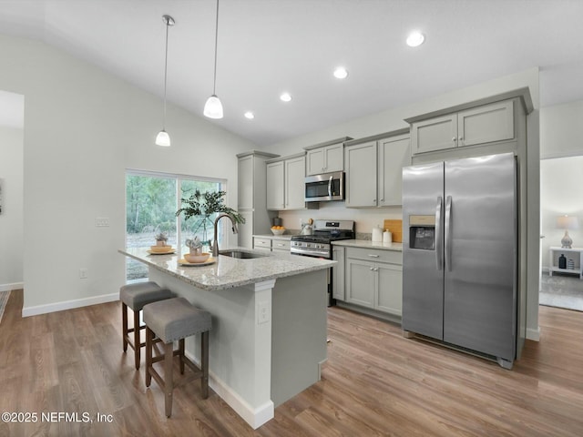 kitchen with light stone countertops, stainless steel appliances, gray cabinetry, and sink