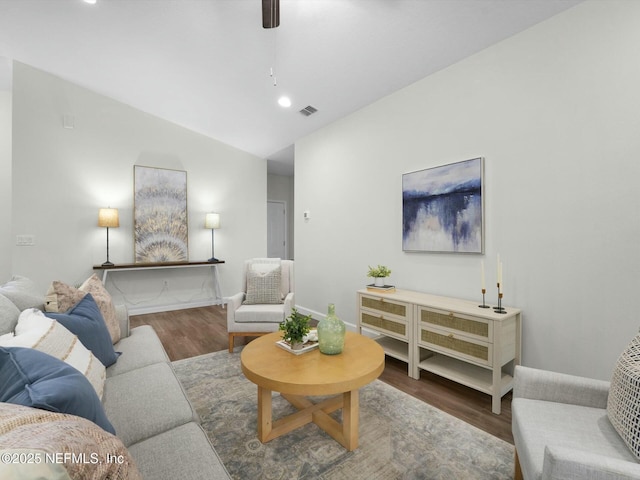 living room featuring ceiling fan, dark hardwood / wood-style floors, and vaulted ceiling