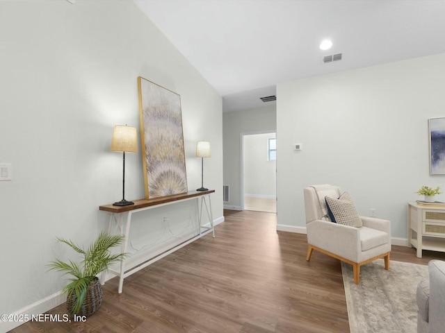 living area with vaulted ceiling and hardwood / wood-style floors