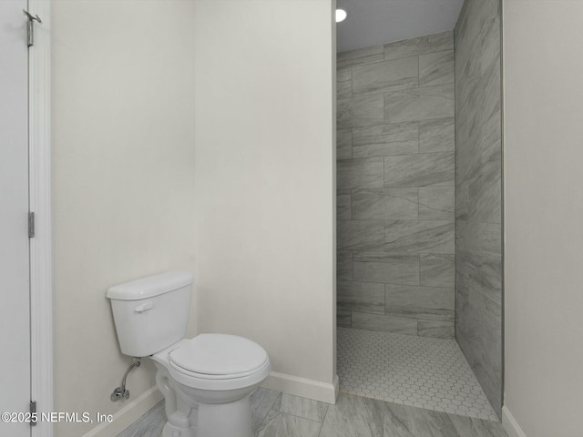 bathroom featuring toilet and tiled shower