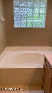 bathroom with a tub to relax in and vanity