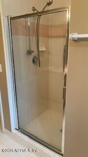 bathroom featuring a shower with door