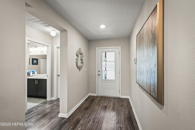 doorway to outside with dark hardwood / wood-style floors and a textured ceiling