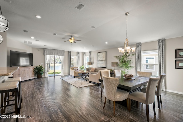 dining room with dark hardwood / wood-style flooring and ceiling fan with notable chandelier