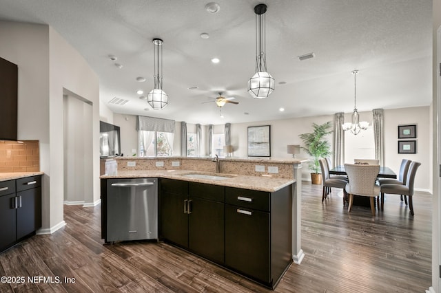 kitchen with a large island with sink, sink, stainless steel dishwasher, and backsplash