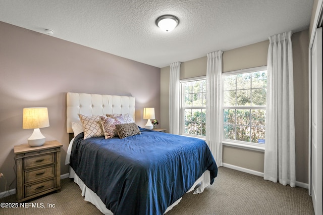 bedroom featuring multiple windows, a textured ceiling, and carpet flooring