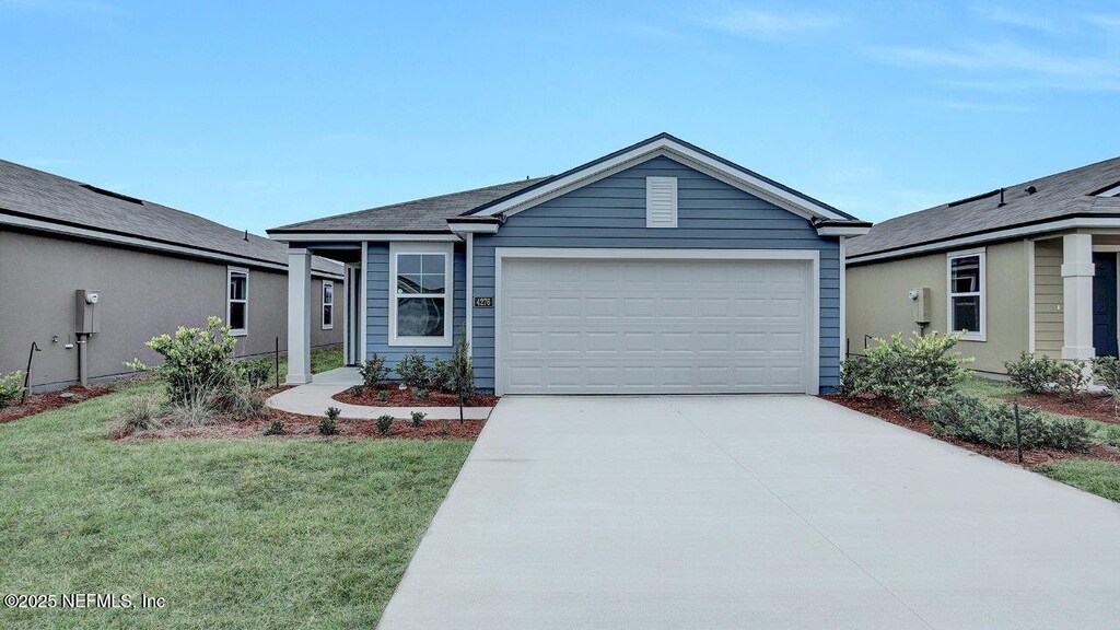 view of front of home featuring a front lawn and a garage